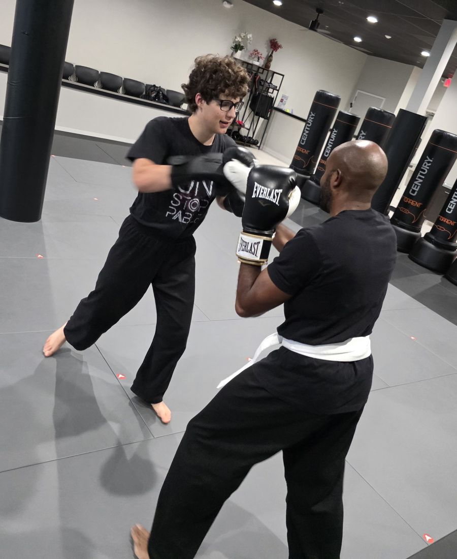Adult student working pads with a coach